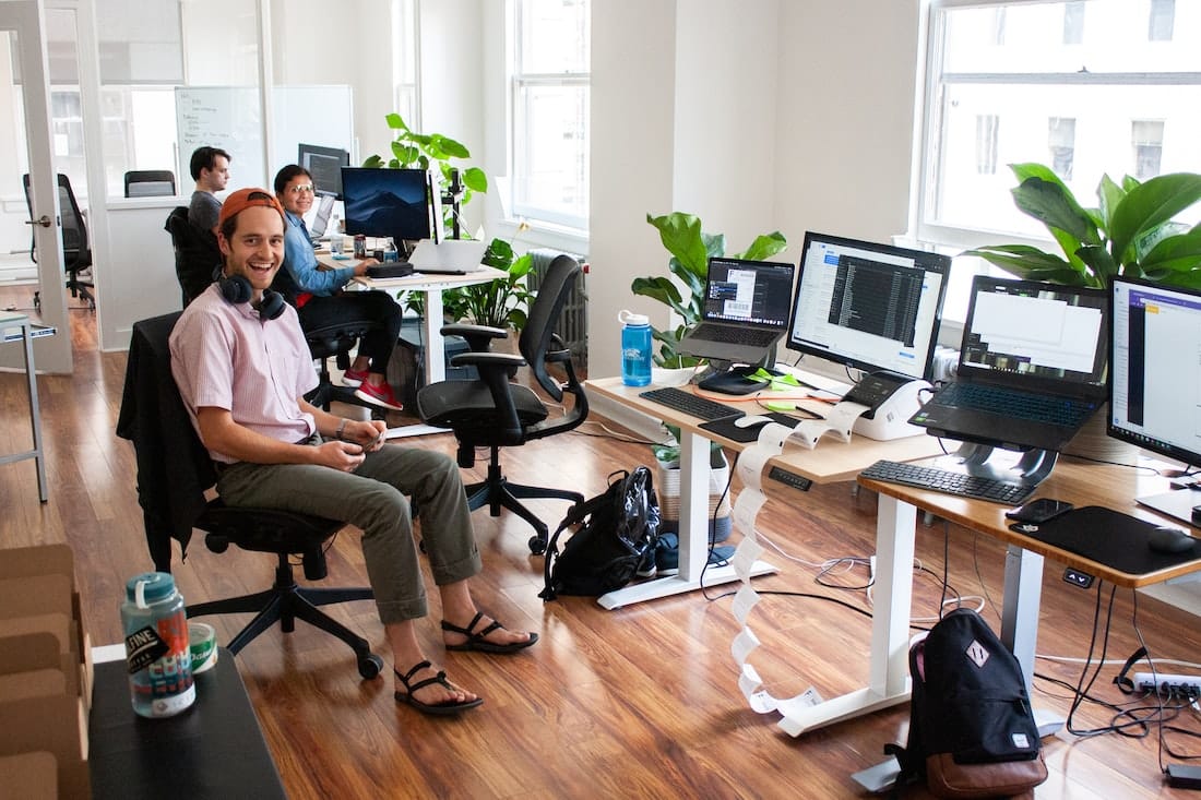 man in blue dress shirt sitting on black office rolling chair